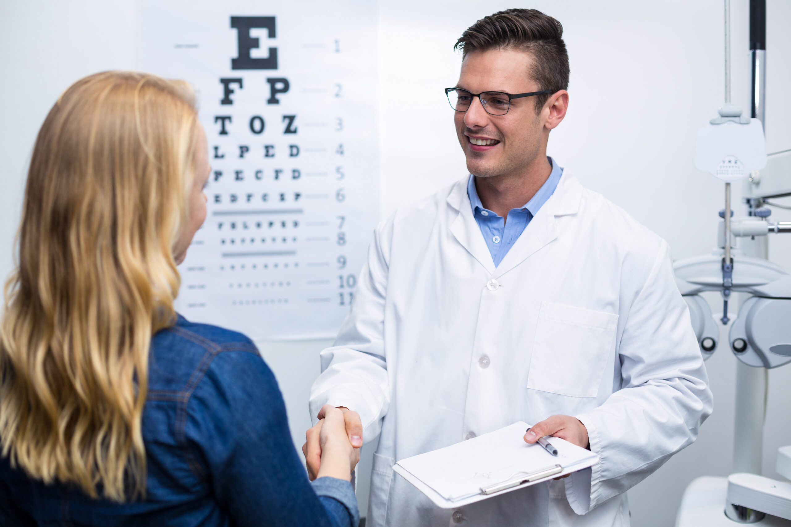Optometrist shaking hands with female patient in ophthalmology clinic 4k